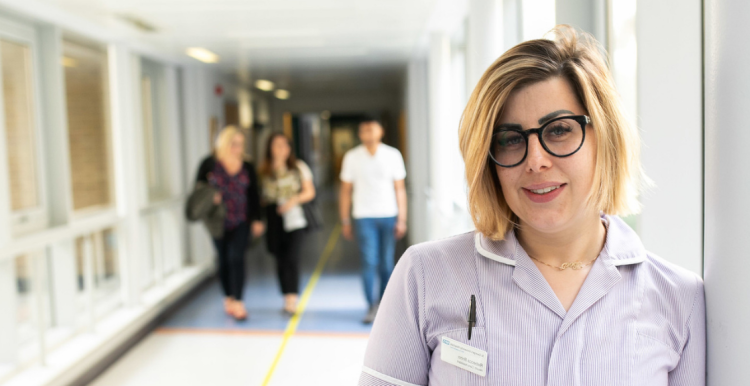 Female nurse stood in a hospital corridor