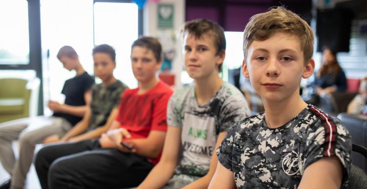 Young boys sitting in a row in a classroom