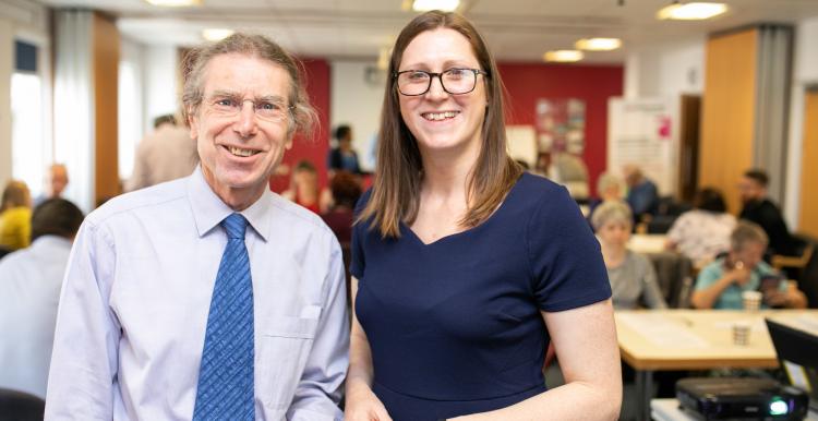 Man and woman standing in a busy room