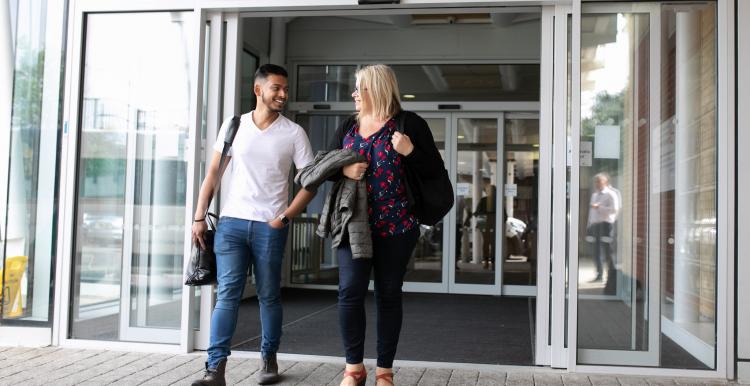 Man and woman walking through sliding doors