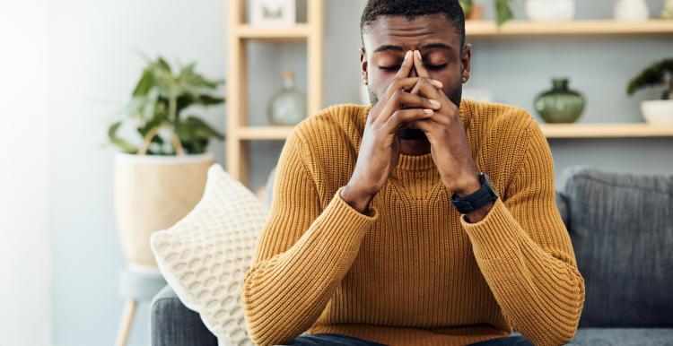 Shot of a young black man looking stressed out at home