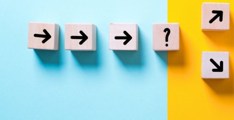 Three small cubes with arrows on them arranged in a line, pointing at a cube with a question mark on. Two arrow cubes branch off from the question mark.