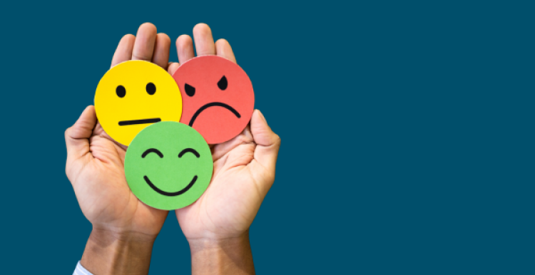 a hand holds three circles in red, yellow, and green, showing angry, neutral, and happy faces respectively.
