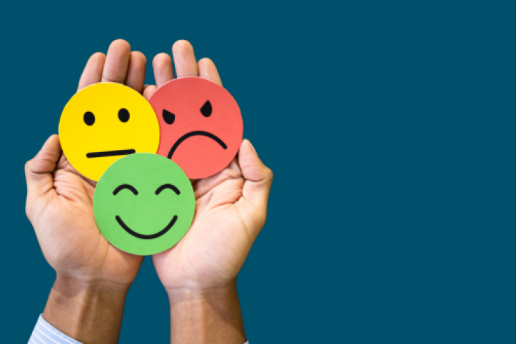 a hand holds three circles in red, yellow, and green, showing angry, neutral, and happy faces respectively.
