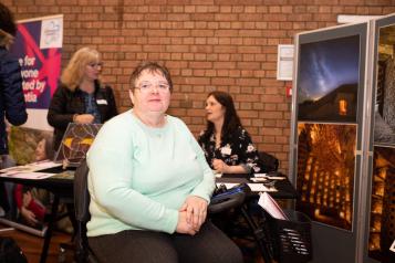 Woman sitting on a mobility scooter at an indoor event