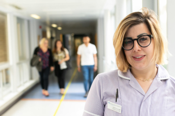 Female nurse stood in a hospital corridor