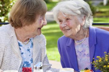 Two older ladies smiling and chatting