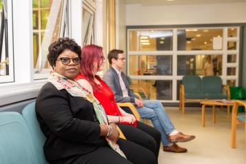 Row of people sitting in a GP waiting room