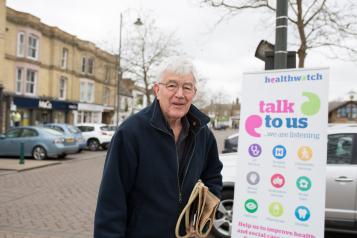 Man standing in front of a Healthwatch banner
