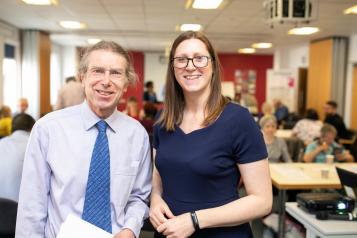 Man and woman standing in a busy room