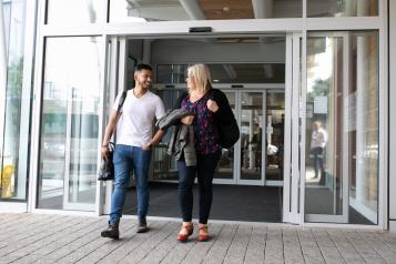 Man and woman walking through sliding doors