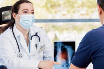 Female doctor showing a patient their x-ray results on a digital screen