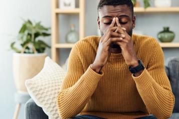 Shot of a young black man looking stressed out at home