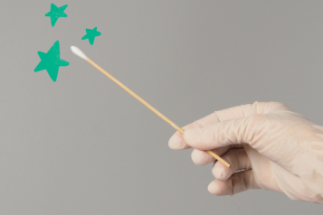 A gloved hand holds a swab. Little green stars float around the swab tip. 